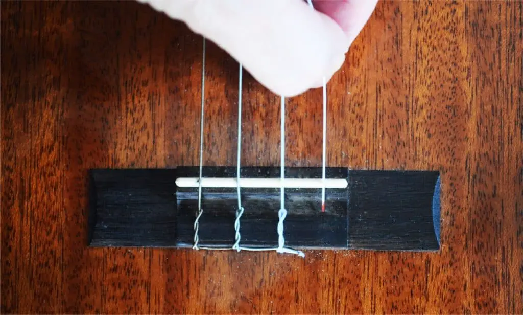 Step 1: The string before insertion into the hole on the tie-block bridge